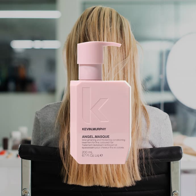 Person with straight blonde hair and pink hair product